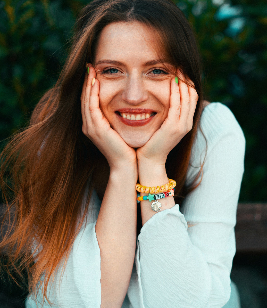 a smiling woman with her hands on her face